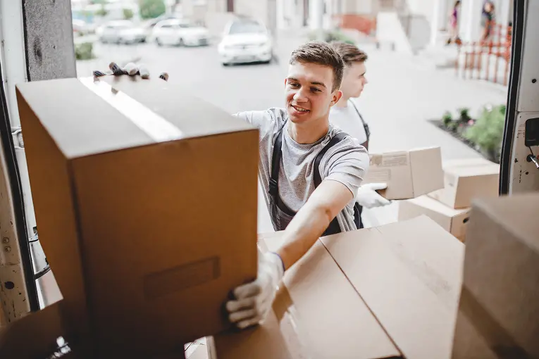 movers Professional movers unpacking boxes from a moving truck