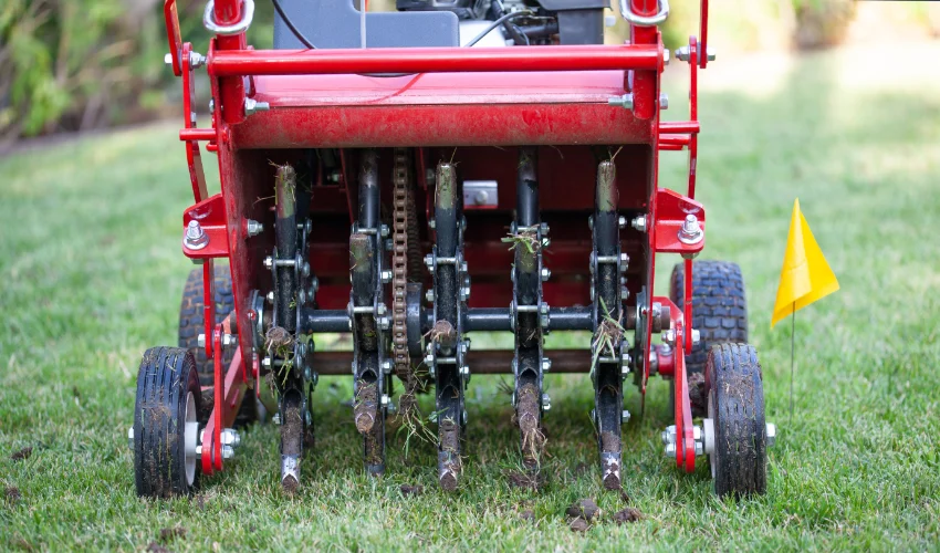 Arrow Environmental Services performing core aeration on a Florida lawn using a professional machine to improve soil health.