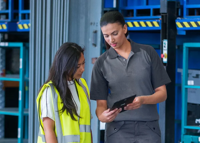 An Arrow Environmental Services specialist reviewing a commercial pest management plan with a warehouse manager at a Florida facility.