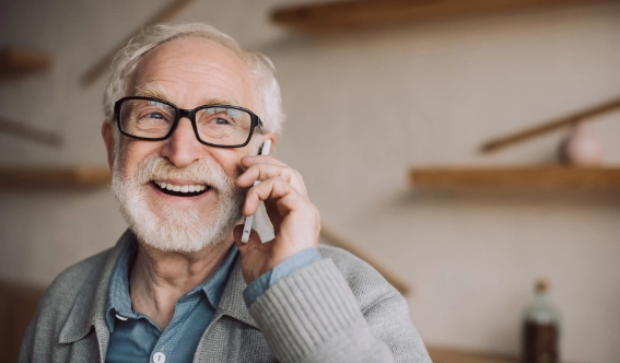 A happy senior man calling Arrow Environmental Services to schedule a residential pest control appointment in Florida.