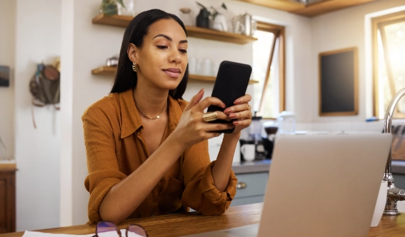 A woman texting Arrow Environmental Services from her kitchen to request a free pest inspection quote in Florida.
