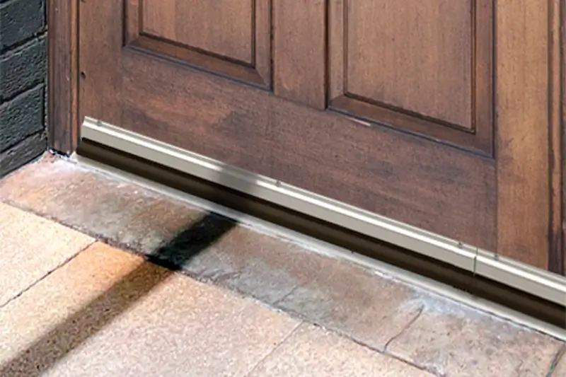 Arrow Environmental Services installing a Flexi-Armour rodent-proof door sweep on a wooden front door in Florida.