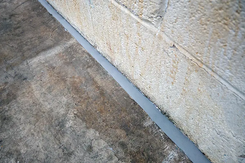Arrow Environmental Services applying industrial-grade sealant to concrete floor cracks to block sub-surface pest entry points.