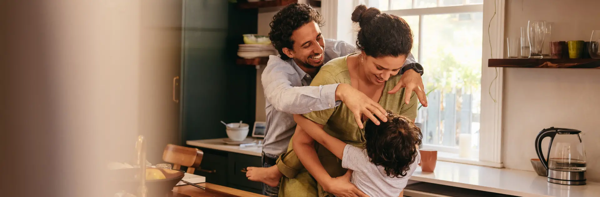A Happy Mother and Father Play with Child in Kitchen of a Pest-Free Home