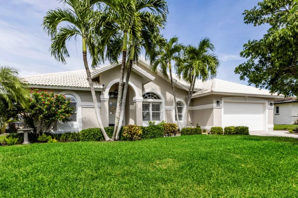 A suburban Florida home with palm trees, protected from infestations by Arrow Environmental Services’ comprehensive residential pest control plans.