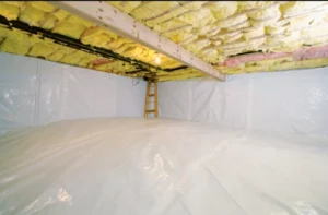 Crawl space with floor and walls sealed with white vapor barriers.